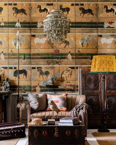 a living room filled with furniture next to a wall covered in animal paintings on the walls