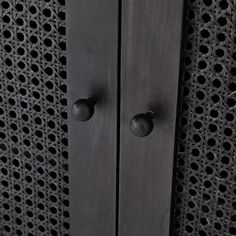 two black metal handles on the side of a wall with holes in it's sides