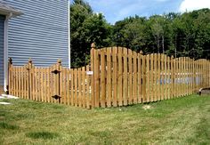 a wooden fence in front of a blue house