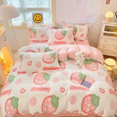 a bed room with a neatly made bed covered in pink and green strawberry print sheets