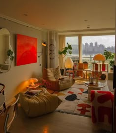 a living room filled with furniture next to a large window overlooking the cityscape