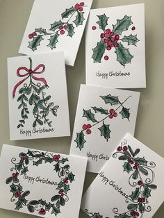 four christmas cards with holly designs on them