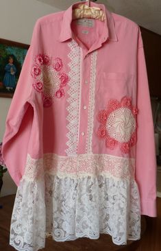 a pink shirt with white lace and flowers on it