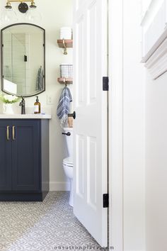 a bathroom with a sink, mirror and toilet in it's corner area next to a door