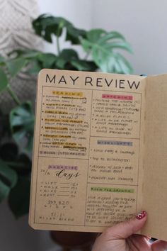 a person holding up an open book with writing on it and plants in the background Year Recap, Bullet Journal Yearly, Monthly Review, Weekly Planner Template