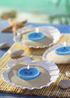 three blue candles sitting on top of white plates