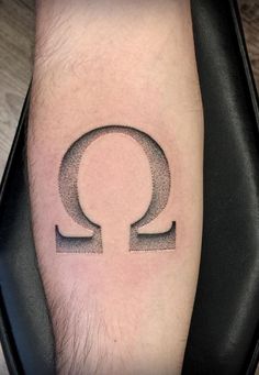 a man with a tattoo on his arm that has an image of the letter q in it