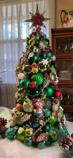 This adorable green (with a touch of red & gold) Christmas tree is one-of-a-kind, made with vintage, mercury glass, & contemporary ornaments.  The tree is adorned with little snowmen, tiny Santas, tiny trees, stars, snowflakes, gingerbread men, & a cre'che, only to mention a few.   These charming, vintage, mercury glass, & shatterproof ornaments are shaped into an amazing Christmas tree embellished with unique, antique, tiny ornaments from the 1950s, 60s & 70s era.  A few are from my private col Vintage Glass Ornament Christmas Tree, Red Gold Christmas Tree, Christmas Ball Tree, Ornament Trees, Tiny Ornaments, Vintage Mercury Glass Ornaments, Tiny Trees, Red Gold Christmas, Vintage Christmas Tree Decorations