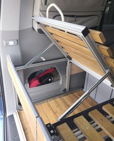 the interior of a van with wood flooring and metal railings on each side