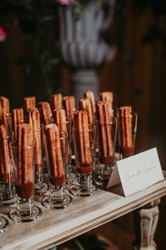 there are many glasses that have food in them on the table with a name card