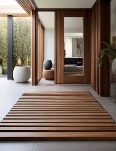 a large wooden mat in the middle of a room with mirrors and vases on either side