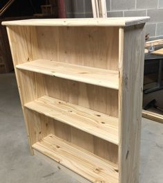 a wooden book shelf sitting inside of a garage