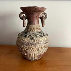 a vase sitting on top of a wooden table