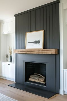 the fireplace is painted black and has a framed photograph on it's mantel