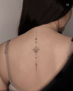 the back of a woman's shoulder with a flower tattoo on it