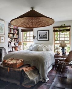 a bedroom with a wicker bed and luggage on the floor in front of a fireplace