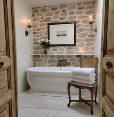 a white bath tub sitting next to a wooden door