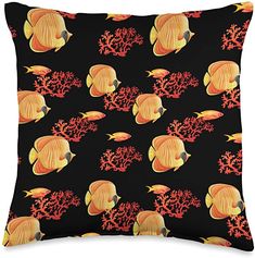 a black pillow with orange fish and corals on the front, against a black background