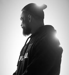 black and white photograph of a man with a beard wearing a hoodie looking off into the distance