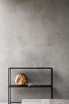 a table with a vase on it next to a book shelf and a wooden object