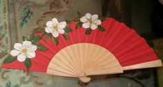 a red fan with white flowers on it