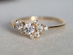 a three stone diamond ring sitting on top of a table