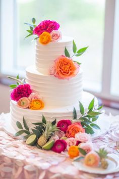 a white wedding cake with flowers on top