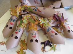 a bunch of leaves with faces on them in a box next to scissors and other items