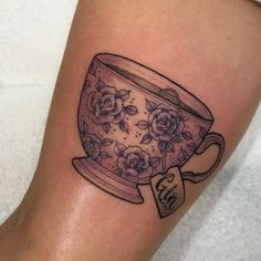 a tattoo on the leg of a woman with a tea cup