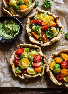 four small pies with different toppings on them