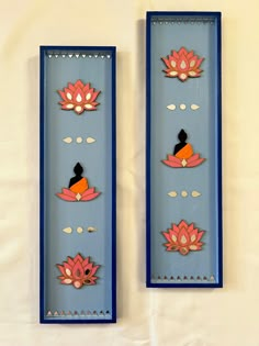 two blue and pink wall hangings with flowers on them