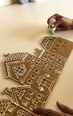 someone is making gingerbread houses out of cardboard and glues them with sharpie markers