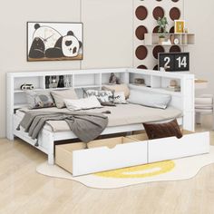 a white bed with drawers underneath it in a room