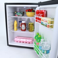 an open refrigerator with drinks and condiments in it on a white table top