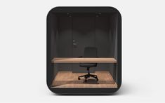 an office cubicle with a desk and chair in the center, surrounded by black walls