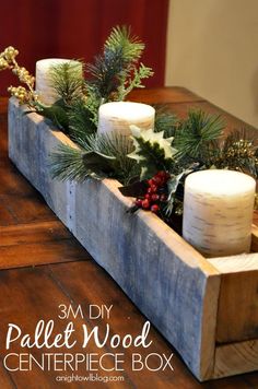 a wooden box filled with candles and greenery