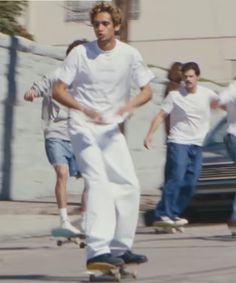 a group of young men riding skateboards down a street