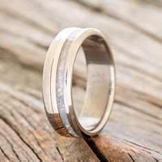 a wedding ring with two wood inlays on top of a piece of wood