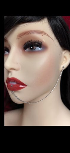 a mannequin head with red lipstick and diamond necklace on it's neck