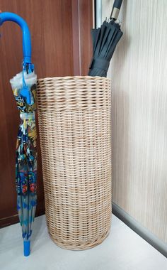 an umbrella is placed in a basket next to the door