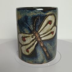 a blue and white cup with a butterfly on it