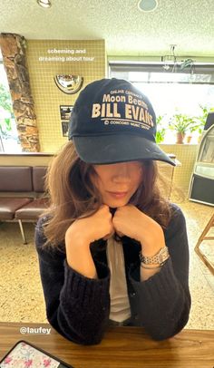 a woman sitting at a table wearing a hat