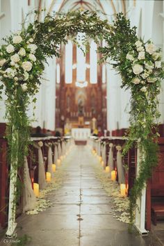 an aisle decorated with white flowers and greenery for a wedding at st mary's church