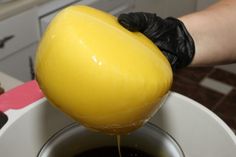 a person pouring liquid into a white cup