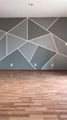 an empty room with wood floors and painted walls