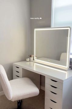 a white chair sitting in front of a desk with a mirror on top of it