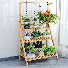 a wooden shelf filled with potted plants on top of a tiled floor next to a window