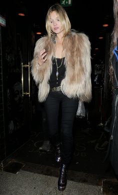 a woman in black pants and a fur coat