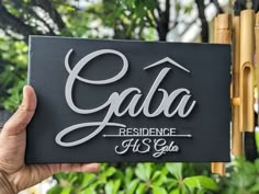 someone holding up a sign that says gaba residence