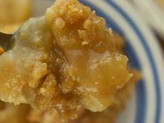 a close up of a spoonful of food on a white and blue striped plate